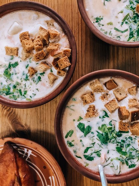 Bowls of creamy soup with croutons and herbs